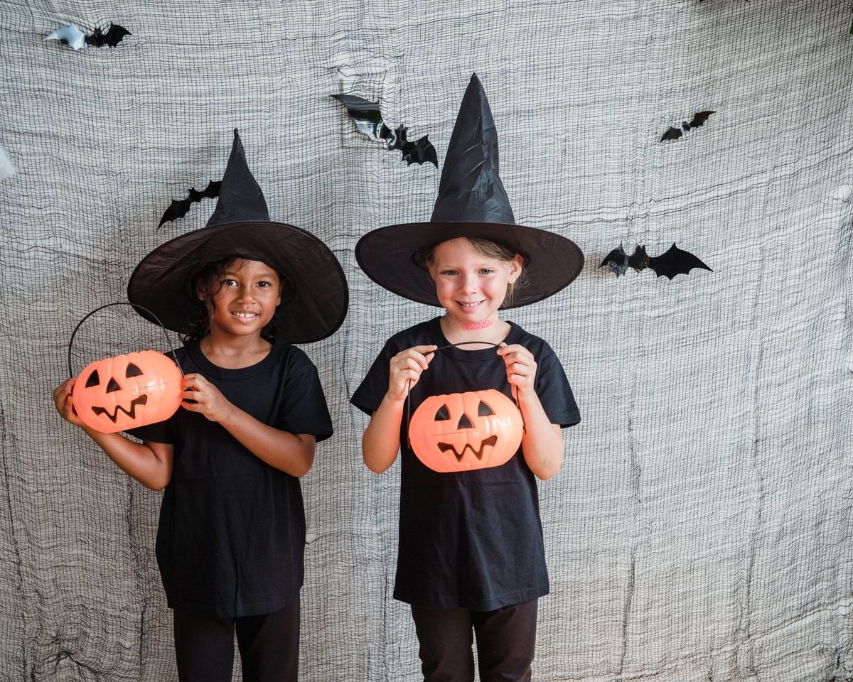 Niños disfrazados de brujos con cestas de calabaza para Halloween